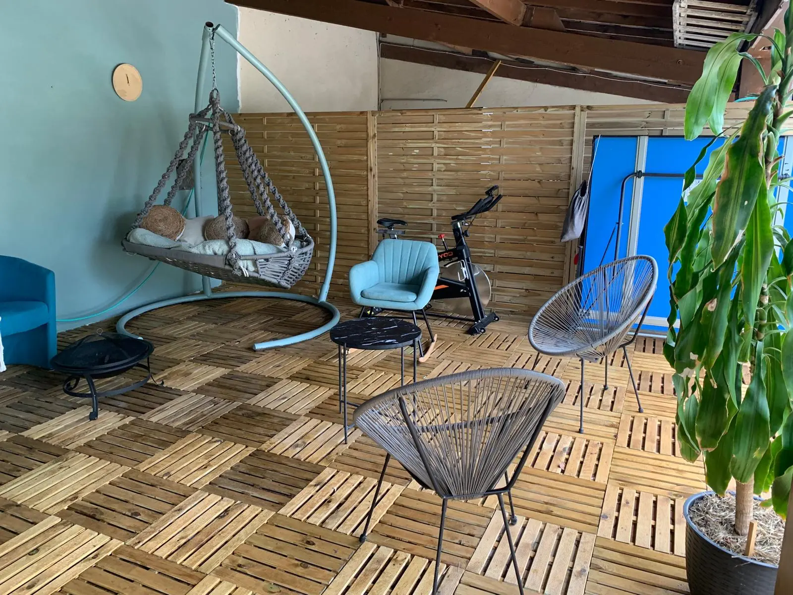 La terrasse couverte avec balancelle, fauteuils et table de ping-pong